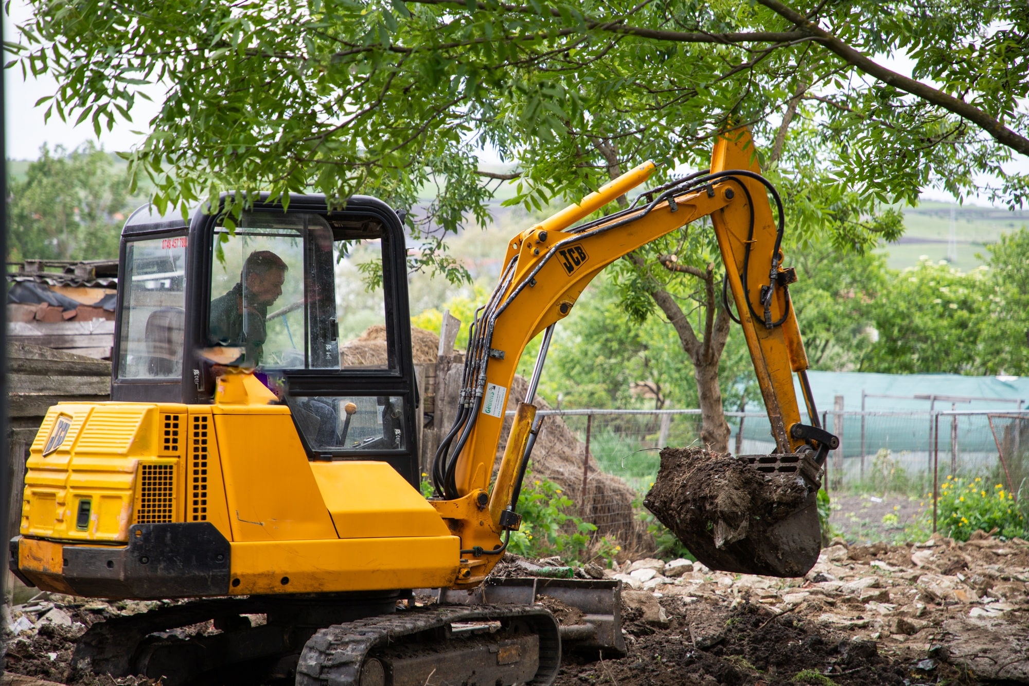 Achat d'une mini pelle . excavator with Bucket lift up are digging the soil in the construction site on